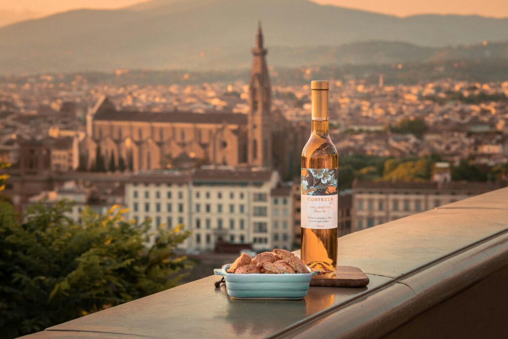 Bottle of wine and biscotti with an evening view of Florence's historic skyline.
