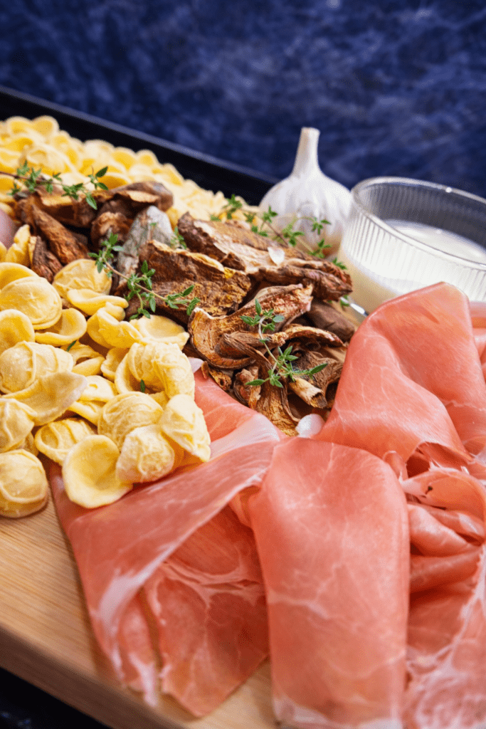 Składniki na orecchiette z grzybami, śmietana, szynka prosciutto crudo, czosnek, tymianek